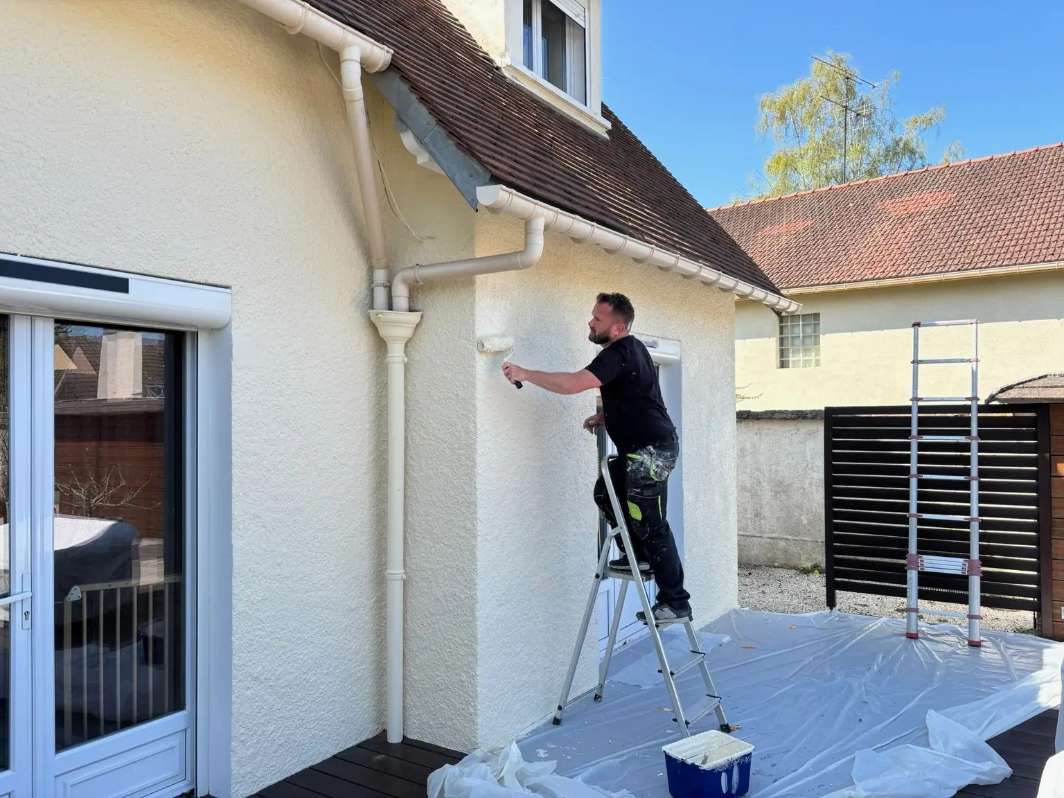 Application régulière d’une peinture extérieure au rouleau sur une façade